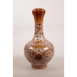 A Chinese red and white porcelain garlic head shaped vase decorated with lotus flowers, peaches