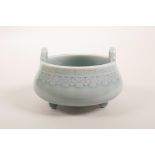 A Chinese celadon glazed two handled pottery censer on tripod feet, seal mark to base, 5" diameter