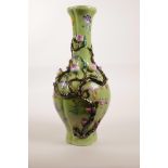 A Chinese polychrome porcelain vase of lobed form with applied peach tree decoration on a green