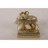 A cast brass seal in the form of a wild boar standing on a plinth, the seal face bearing a coat of