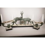 A French Art Deco three piece garniture of two spelter deer on an onyx and marble base, 27" long,