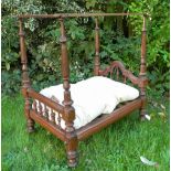 A good carved wooden four poster dolls bed, English circa 1890,