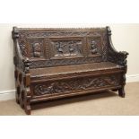 Early 20th century heavily carved oak hall bench seat, carved with warrior heads, jousting knights,