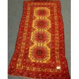 Turkmen red and yellow ground rug, quadruple stylised medallion,