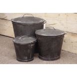 Three graduating metal buckets with beaten shaped lids