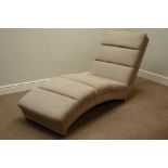 Shaped lounger chair upholstered in neutral fabric,