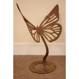 Rusted pierced wrought iron garden sculpture of a butterfly on stand,