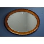 Early 20th century walnut oval framed mirror, bevelled glass plate,