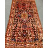 3871 Persian Shiraz red ground rug, stylised animal motifs, geometric overall design,