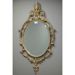 Ornate scrolling gilt metal framed oval mirror, bevelled glass plate,