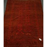 Afghan red ground rug, stylised decoration,