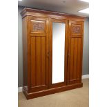 Edwardian walnut triple wardrobe, two panelled doors and central glazed door,