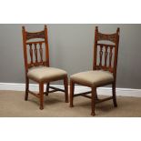 Arts and Crafts walnut framed side chairs, relief carved top rail above three pierced splats,