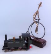 Model of an 0-4-0 steam locomotive and a part brass model of a man on a Penny Farthing bicycle (2)