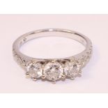 Three stone brilliant cut diamond white gold ring with diamond shoulders hallmarked 18ct with