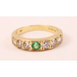 18ct gold ring set with six diamonds and a central emerald hallmarked