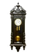 Large Victorian Vienna ebonised wall clock with urn cresting, circular dial with subsidiary seconds,