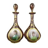 Pair of 19th century cranberry glass decanters with hand painted portrait panels an gilt overlay,