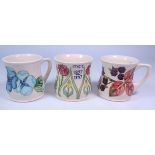 Group of three Moorcroft mugs; MCC 1897-1997 Centenary mug by Rachel Bishop,