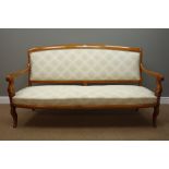 Early 20th century walnut framed settee, scrolling arms and supports, upholstered in cream fabric,