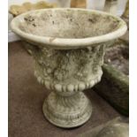 Stone effect urn, decorated with fruit and mythical masks,