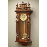 Late Victorian walnut cased Vienna type wall clock, cresting with turned finials,