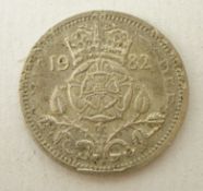 Coin - round coin which appears to be a sixpence but has a print on top of a 1982 twenty pence coin