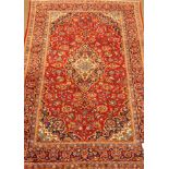 Persian Kashan red ground rug carpet, central medallion on field of interlacing stylised flowers,