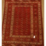 Persian Bokhara red ground rug, repeating Gul design,