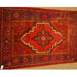 Persian Hamadan red ground rug, central lozenge with tree of life and animal motifs,