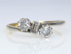 Three stone baguette and round brilliant cut diamond crossover ring stamped 18ctPLAT approx 0.