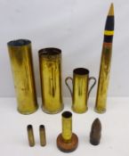 Brass trench art shell case, two larger shell cases, three smaller shell cases one mounted on wood,