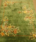 Oriental washed woollen green ground rug carpet decorated with flowers, outlined border in orange,