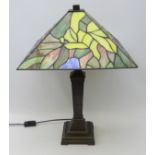 Tiffany style table lamp, with leaded and slag glass shade on a bronzed cast metal base,