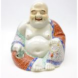 20th century porcelain figure of Hotei, seated wearing flowing robes,