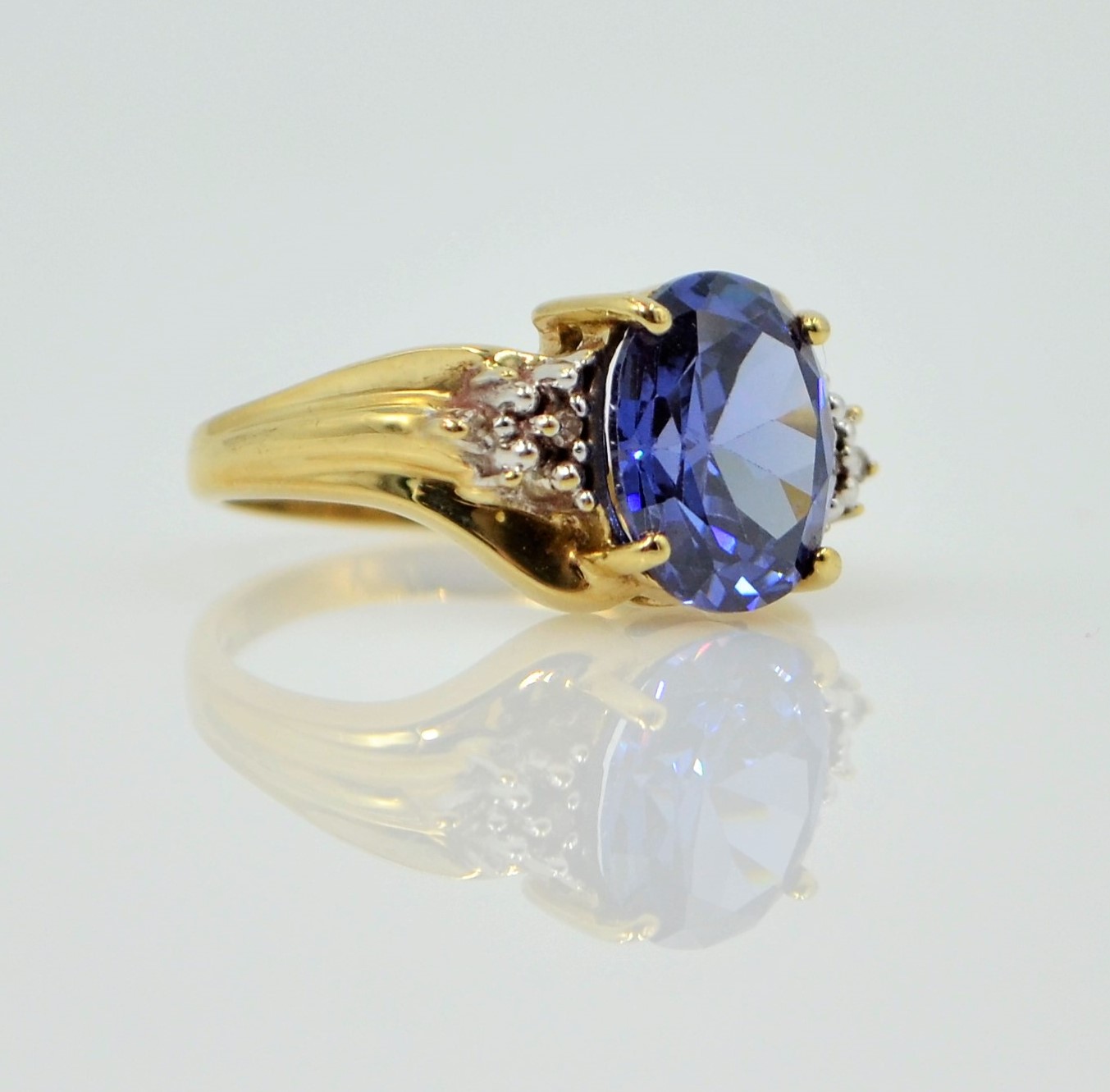 Gold dress ring set with a blue stone and diamond shoulders hallmarked 9ct Condition