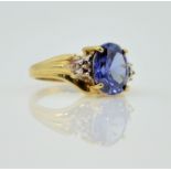 Gold dress ring set with a blue stone and diamond shoulders hallmarked 9ct Condition