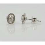 Pair of 18ct white gold diamond stud ear-rings oval halo design approx 0.