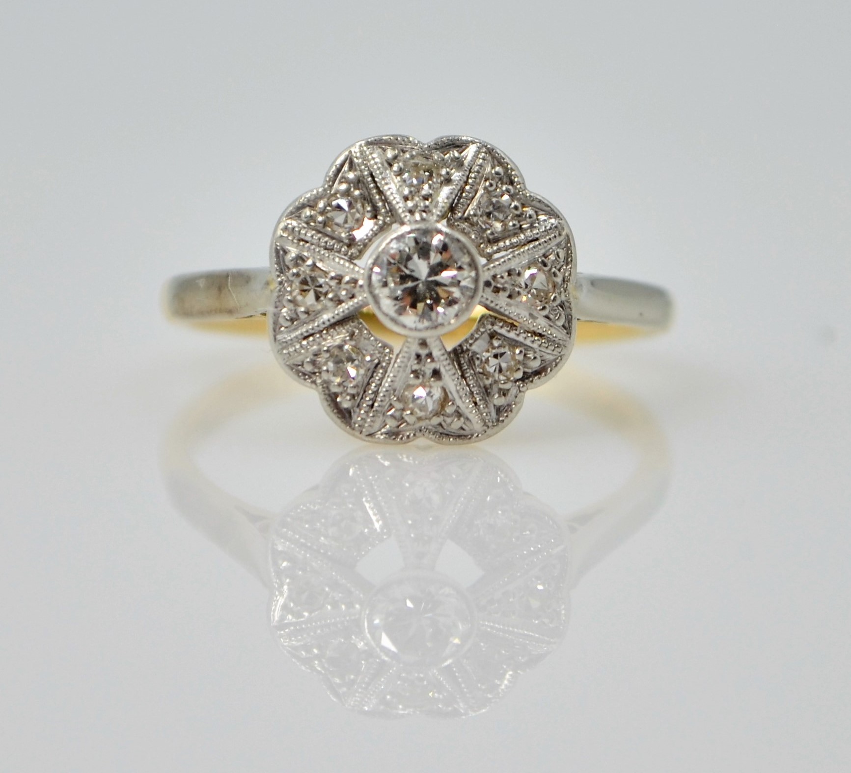 Art Deco platinum set diamond flower cluster ring on 18ct gold shank stamped 18ct.