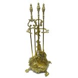 Early 20th century ornate brass three piece companion stand with hunting theme decoration,