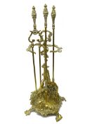 Early 20th century ornate brass three piece companion stand with hunting theme decoration,