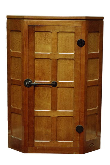 'Mouseman' panelled oak corner cupboard, single door with wrought metal fittings,