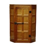 'Mouseman' panelled oak corner cupboard, single door with wrought metal fittings,