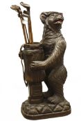 20th century Black Forest umbrella stand in the form of a snarling bear in a cap holding a golf