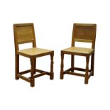 Pair 'Mouseman' oak dining chairs, panelled adzed back, seat upholstered in studded soft leather,