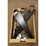 Collection of vintage tools including three saws, moulding plane, three sharpening stones,