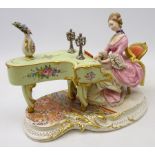 Capodimonte figure of a lady playing the piano, signed D.