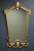 Wall mirror in gilt scroll work frame with oval Serves style porcelain inset,