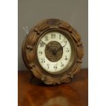 Early 20th century single train timepiece, in beech wood surround carved with leaves and berries,