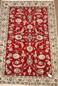 Red and ivory ground Persian rug, scrolling floral design,